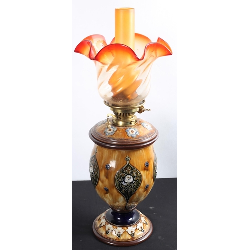 121 - A ROYAL DOULTON OIL LAMP the clear glass and ruby glass shade above a baluster shaped base decorated... 