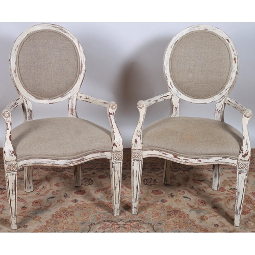 14 - A PAIR OF CONTINENTAL VINTAGE WHITE PAINTED ARMCHAIRS each with an oval upholstered back and seat wi... 