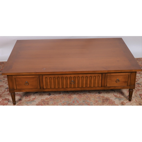 16 - A DU PLESSIS CHERRYWOOD COFFEE TABLE of rectangular outline the shaped top above three frieze drawer... 