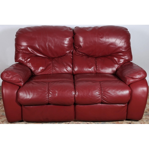 637 - A WINE HIDE UPHOLSTERED TWO SEATER SETTEE with shaped arms 
161cm (w)