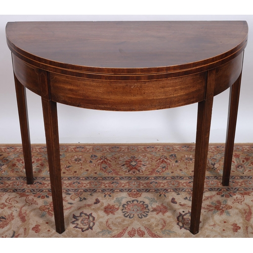 236 - A GEORGIAN MAHOGANY FOLDOVER SUPPER TABLE of demi lune outline the shaped hinged top above a moulded... 