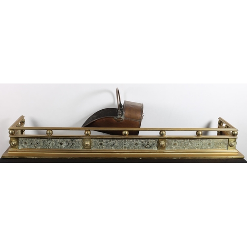 375 - A GOOD 19TH CENTURY BRASS FENDER the shaped top rail above an engraved frieze on platform support to... 