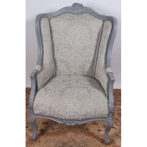 711 - A CONTINENTAL GREY PAINTED AND UPHOLSTERED WING CHAIR the shaped top rail with flowerhead and foliat... 