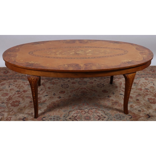 687 - A CONTINENTAL WALNUT INLAID COFFEE TABLE of oval outline the shaped top inlaid with flowerheads, fol... 