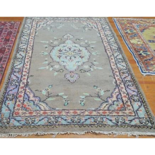 173 - A WOOL RUG the light grey, beige and light blue ground with central panel filled with stylised flowe... 