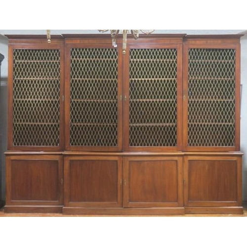 180 - A GEORGIAN MAHOGANY FOUR DOOR LIBRARY BOOKCASE of breakfront outline the moulded cornice above four ... 