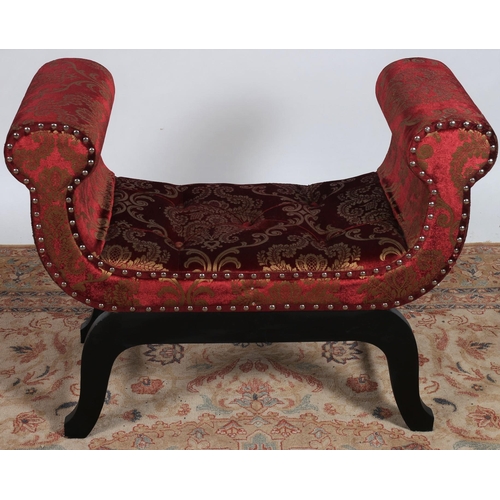 195 - AN EBONISED AND UPHOLSTERED STOOL the buttoned upholstered seat with scroll over arms on splayed leg... 