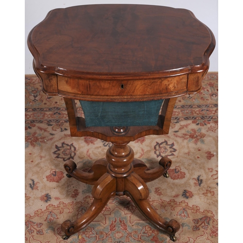 252 - A WALNUT OCCASIONAL TABLE of serpentine outline the shaped top with frieze drawer and work basket ab... 