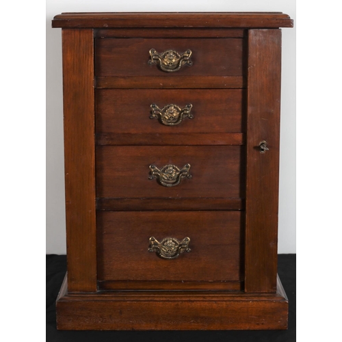 257 - A VINTAGE MAHOGANY MINIATURE WELLINGTON CHEST of rectangular outline the shaped top above four long ... 