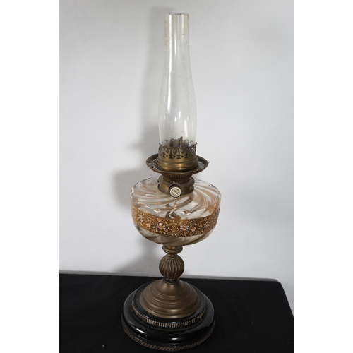 277 - A VINTAGE BRASS AND GLAZED OIL LAMP raised on a circular spreading foot (lacking shade)
65cm (h)