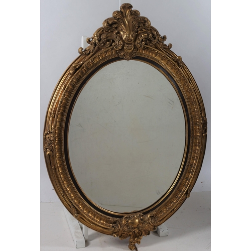 353 - A CONTINENTAL GILT FRAME MIRROR the oval plate within a beadwork and foliate decorated frame with C-... 