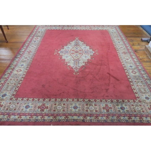 548 - A WOOL RUG the pink and off white ground with central panel filled with stylised flowerheads and fol... 