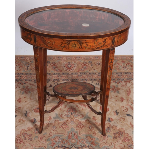 62 - A 19TH CENTURY SATINWOOD INLAID CURIO TABLE of oval outline the shaped top with bevelled glazed hing... 