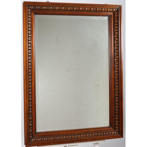 648 - A CHERRYWOOD FRAMED MIRROR the rectangular bevelled glass plate within an egg and dart moulded frame... 