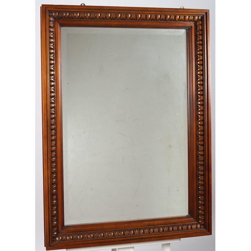 649 - A CHERRYWOOD FRAMED MIRROR the rectangular bevelled glass plate within an egg and dart moulded frame... 