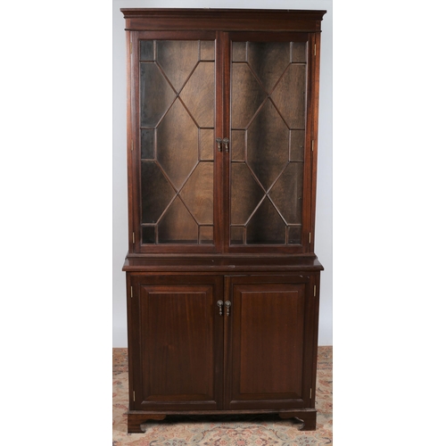 743 - A MAHOGANY TWO DOOR LIBRARY BOOKCASE the moulded cornice above a pair of astragal glazed doors conta... 