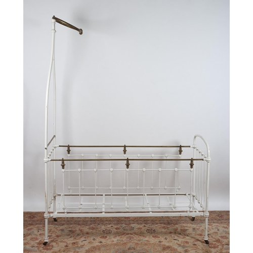 A 19TH CENTURY CAST IRON CHILD'S COT WITH BRASS CANOPY of rectangular outline with cylindrical barri