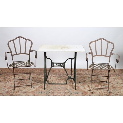 A WROUGHT IRON SINGER SEWING MACHINE BASE PATIO TABLE surmounted by a white veined marble top raised