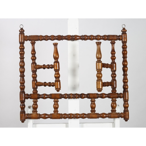 530 - A STAINED BEECHWOOD WALL MOUNTED COAT HANGER of rectangular bobbin form with two hinged hangers 
53c... 