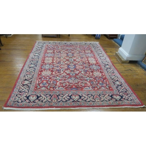 541 - A LILIAN WOOL RUG the wine and indigo ground with central panel filled with stylised flowerheads and... 