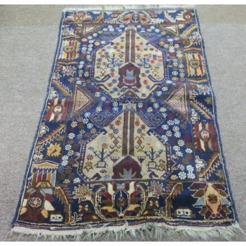 547 - A KAZAK PRAYER RUG the indigo and beige ground with central panel filled with stylised flowerheads, ... 