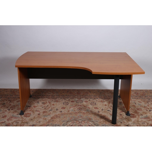 704 - A MODERN TEAK VENEER AND TUBULAR DESK the shaped top raised on cylindrical support with panel ends 
... 