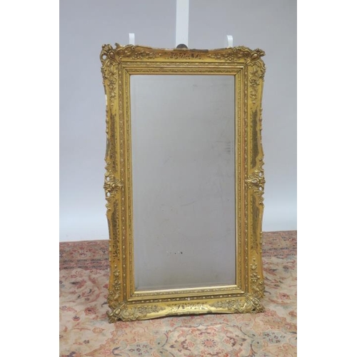 722 - A 19TH CENTURY GILTWOOD AND GESSO MIRROR the rectangular bevelled glass plate within a foliate and f... 