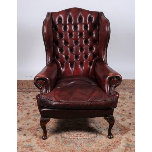 84 - A VINTAGE GEORGIAN DESIGN MAHOGANY AND HIDE UPHOLSTERED WING LIBRARY ARMCHAIR with deep buttoned uph... 