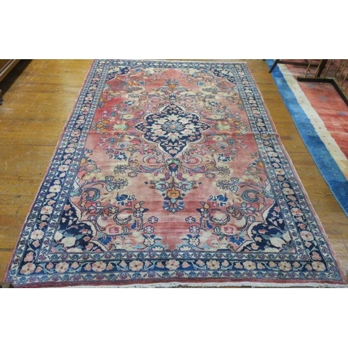 174 - A LADIK WOOL RUG the light pink shaded ground with central panel filled with stylised flowerheads an... 