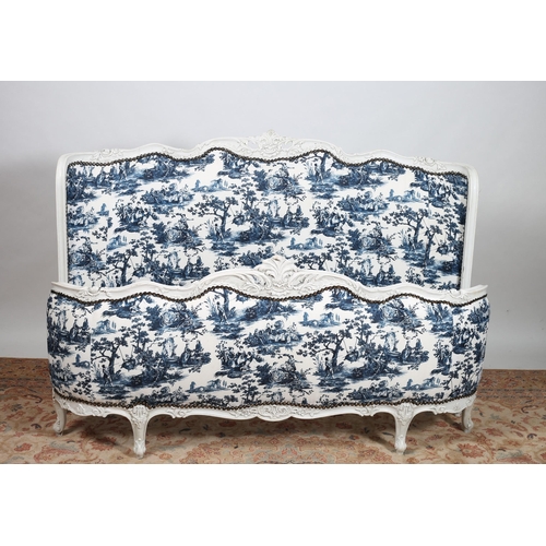 250 - A CONTINENTAL WHITE PAINTED AND UPHOLSTERED BED the shaped headboard with foliate carved cresting ab... 