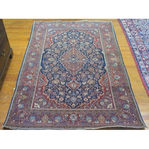 357 - AN ORIENTAL WOOL RUG the indigo and wine ground with central panel filled with stylised flowerheads ... 