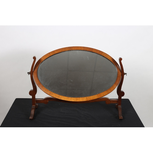 742 - A VINTAGE MAHOGANY CRUTCH FRAME MIRROR the oval plate within a moulded frame raised on scroll suppor... 