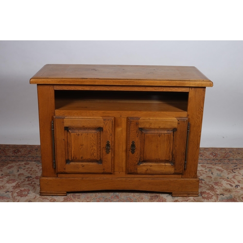 804 - A CONTINENTAL OAK SIDE CABINET of rectangular outline the shaped top above an open compartment the b... 