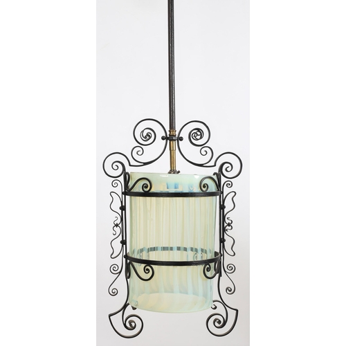 850 - A VINTAGE VASELINE GLASS AND WROUGHT IRON CENTRE LIGHT the scroll frame containing a vaseline glass ... 