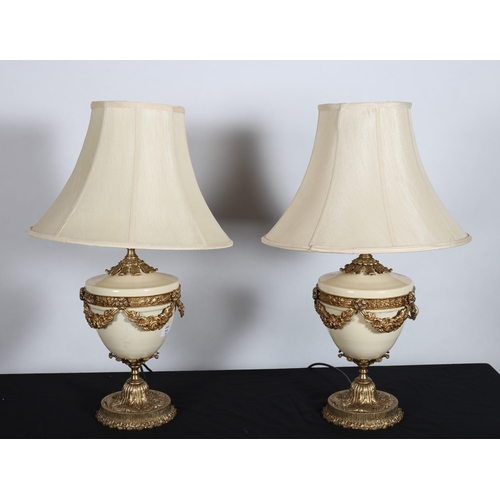 112 - A PAIR OF CONTINENTAL GILT BRASS AND TOLEWARE TABLE LAMPS each of urn form hung with floral festoons... 