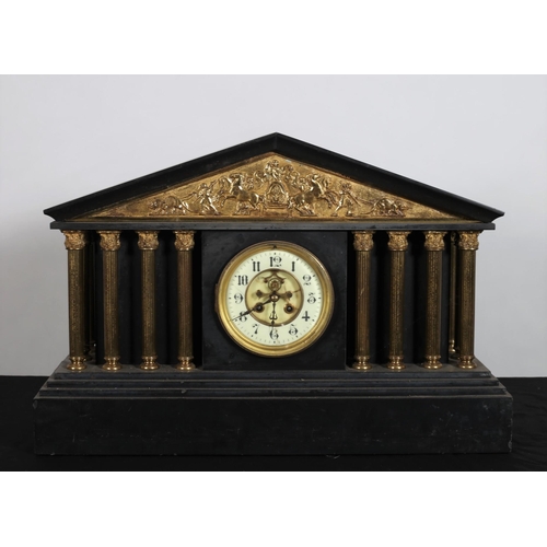 113 - A VINTAGE BLACK MARBLE AND GILT BRASS MANTLE CLOCK of architectural outline the frieze with brass em... 