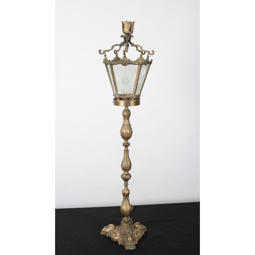 119 - A GILT BRASS TABLE LAMP in the form of a lantern the etched glass panels above a baluster column on ... 