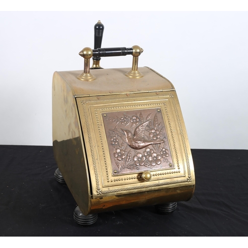 123 - A VINTAGE BRASS AND COPPER FUEL BIN the hinged slope with embossed panel depicting a bird amongst fo... 