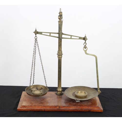 126 - A 19TH CENTURY BRASS WEIGHING SCALES the knopped column above a rectangular mahogany base with five ... 