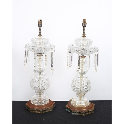 134 - A PAIR OF CUT GLASS TABLE LAMPS each of baluster form hung with lustre drops raised on a shaped whit... 