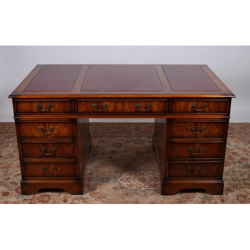 15 - A MAHOGANY PEDESTAL DESK of rectangular outline the shaped top with tooled leather insets above thre... 