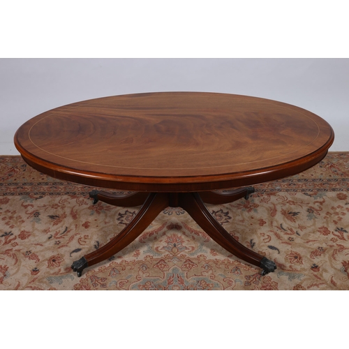 193 - A MAHOGANY COFFEE TABLE of oval outline the shaped top above a turned column on quadruped splayed le... 