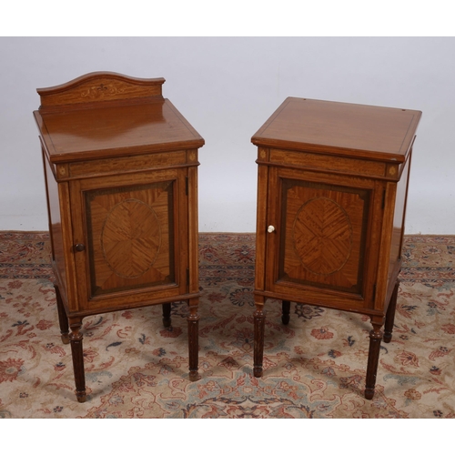 213 - A PAIR OF EDWARDIAN SATINWOOD BEDSIDE PEDESTALS each of rectangular outline the shaped top above a c... 