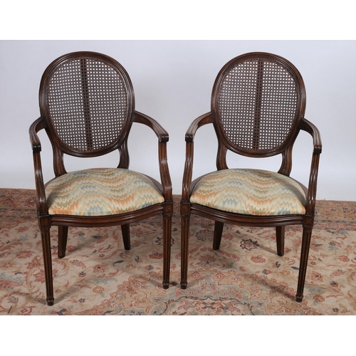 229 - A PAIR OF CONTINENTAL MAHOGANY BERGÈRE AND UPHOLSTERED ELBOW CHAIRS each with an oval caned back wit... 