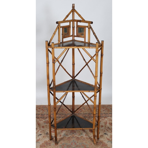 264 - A VINTAGE BAMBOO AND BLACK LACQUERED THREE TIER CORNER WHATNOT the superstructure with bevelled glas... 