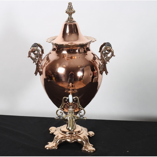 291 - A VICTORIAN COPPER AND BRASS SAMOVAR of bulbous form with ebonised carrying handles above a shaped b... 