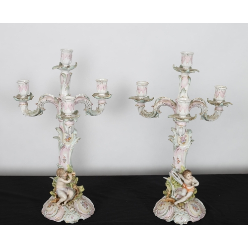 305 - A PAIR OF SITZENDORF FOUR BRANCH CANDELABRAS with foliate scroll arms and drip pans raised on a natu... 