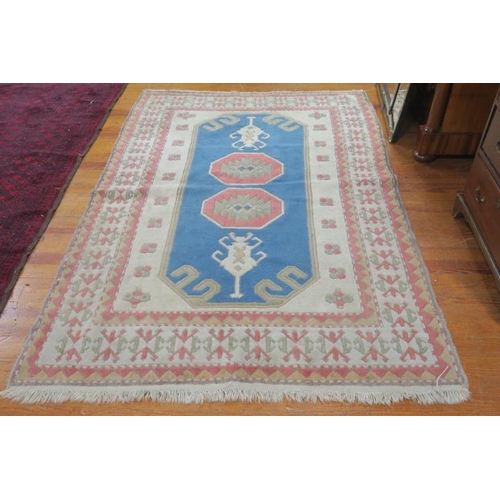 360 - A WOOL RUG the light blue and beige ground with central panel filled with octagonal serrated panels ... 