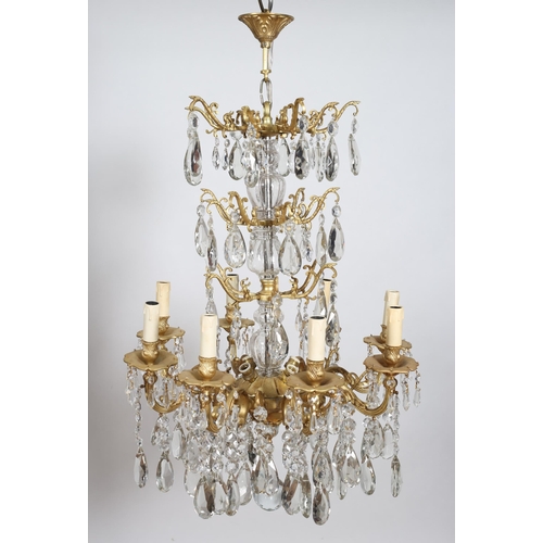 381 - A CONTINENTAL GILT BRASS AND CUT GLASS EIGHT BRANCH CHANDELIER hung with faceted chains and pendants... 