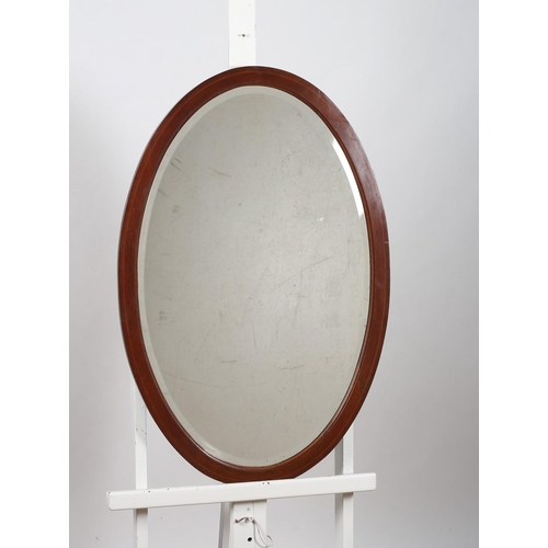 724 - A VINTAGE MAHOGANY AND SATINWOOD INLAID MIRROR the oval bevelled glass plate within a moulded frame ... 